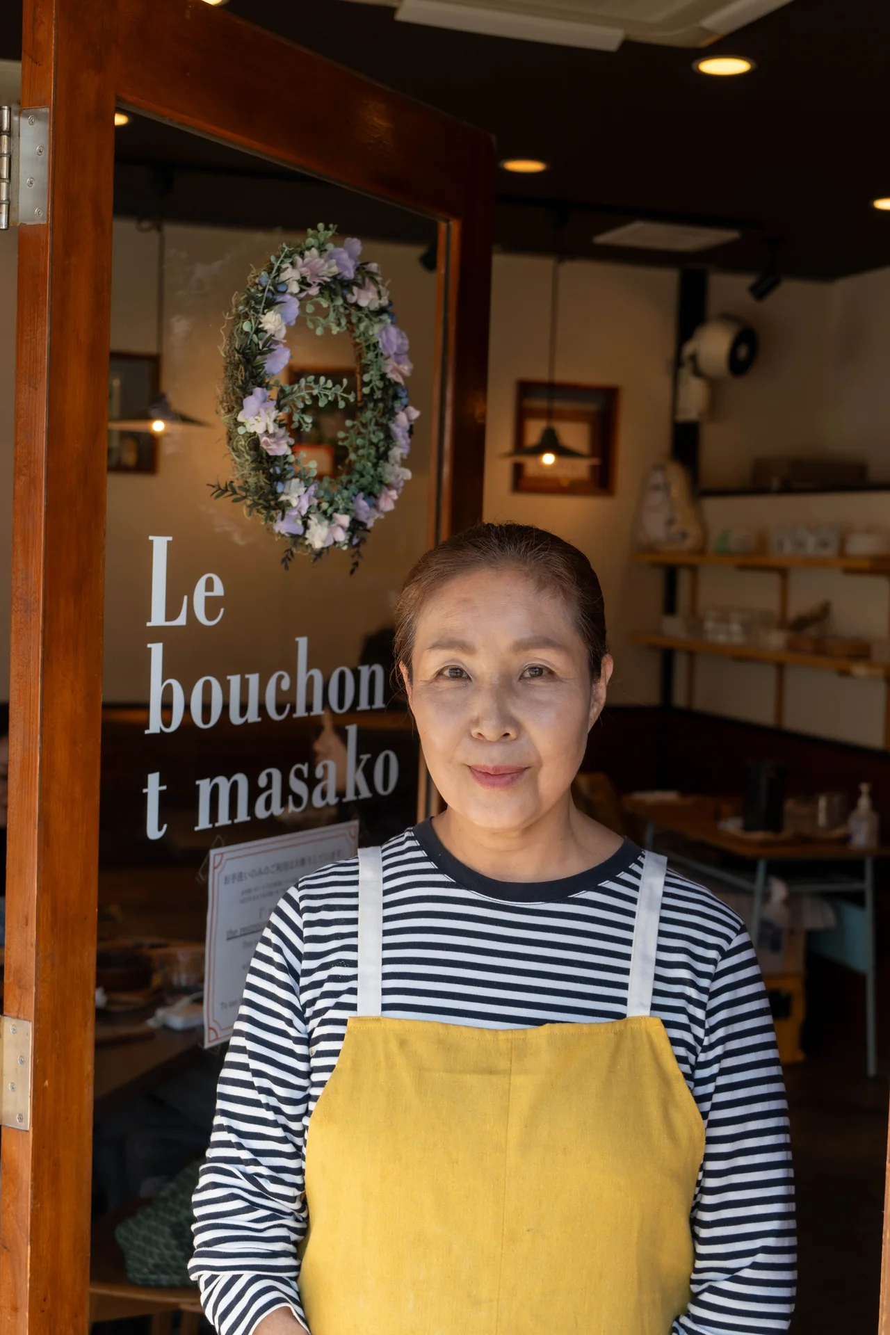 The cook in a yellow apron at the restaurant entrance
